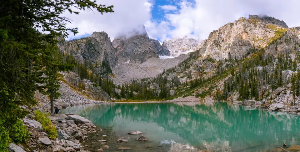 Turquoise glacial water of Delta Lake below the granite peaks of the Grand Teton, cloud on the summit
